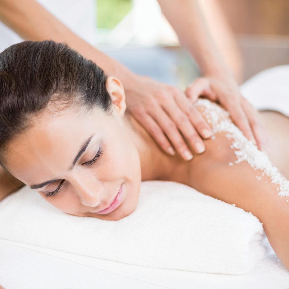 Woman getting salt scrub during her massage
